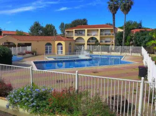 une maison avec une clôture autour d'une piscine dans l'établissement Appartement à Canet 4 couchages avec parking et piscine, à Canet