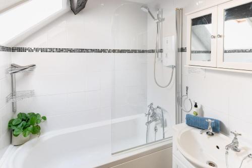 ein weißes Badezimmer mit Badewanne und Waschbecken in der Unterkunft Tranquil 2 bed cottage Sidmouth, rural escape in Salcombe Regis