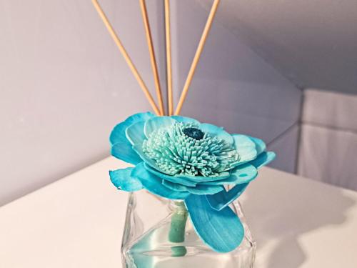 a blue flower in a glass vase on a table at Apartment Siebter Himmel by Interhome in Bad Ischl