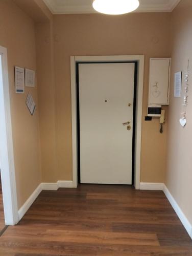 an empty room with a white door and wooden floors at Casa della Nonna Pasqua in Taranto