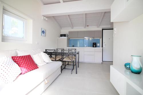 a white living room with a white couch and a table at Residence Il Poggio in Dorio