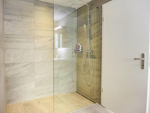 a bathroom with a shower with a glass door at Apartment Huus Chloster- Apt Niesen by Interhome in Krattigen