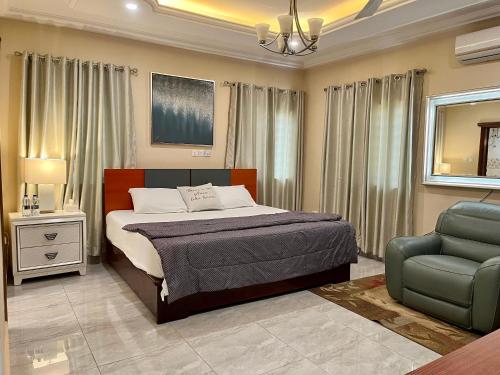 a bedroom with a bed and a chair at The African Palace- Free Airport Pick up - High Speed Starlink WiFi - Car Rental in Tamale
