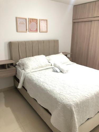 a bedroom with a large bed with white sheets at Comfortable 2 bedroom apartment with pool in Miramar in Barranquilla
