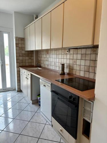 une cuisine avec des armoires blanches et un four à plaques de cuisson dans l'établissement La tour d'ivoir, à Toulon