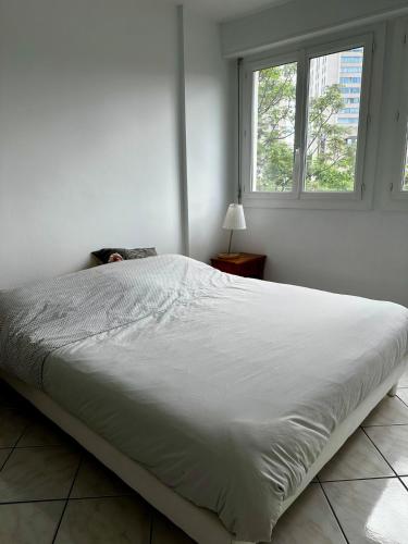 un grand lit blanc dans une chambre avec une fenêtre dans l'établissement La tour d'ivoir, à Toulon