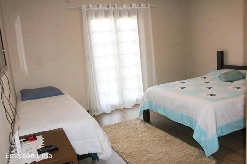 a bedroom with two beds and a window at Casa do Pico in Santo Antônio do Pinhal