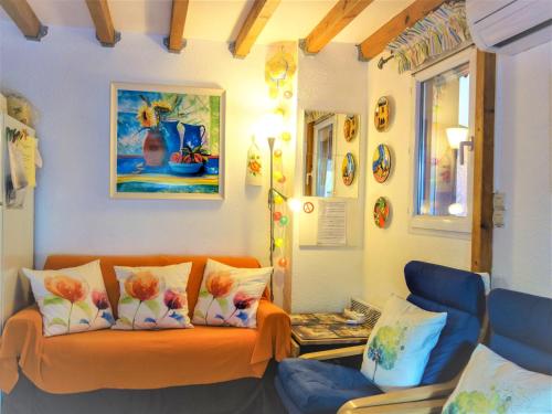 un salon avec un canapé orange avec des fleurs dessus dans l'établissement Holiday Home Les Marines du Roussillon-1 by Interhome, à Saint-Cyprien