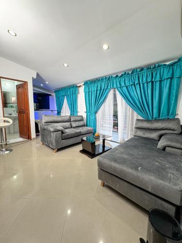 a living room with blue curtains and a couch at Hotel Puerto Bahia in San Gil