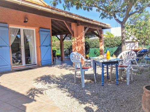 une table et deux chaises assises sous un pavillon dans l'établissement Holiday Home Les Marines du Roussillon-1 by Interhome, à Saint-Cyprien
