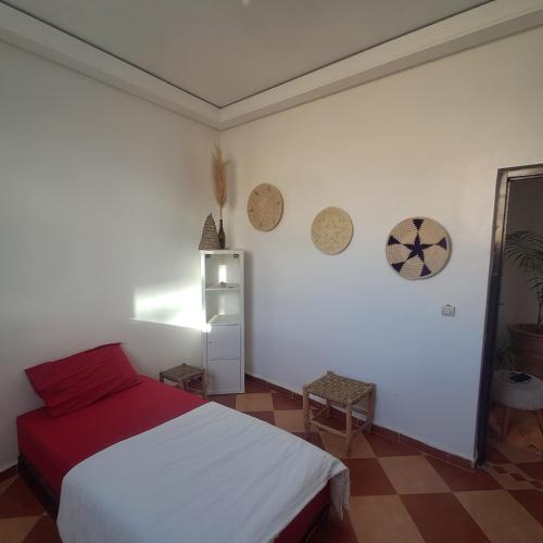 a bedroom with a white bed and a red blanket at Buena vista morroco GUEST HOUSE in Tamraght Ouzdar