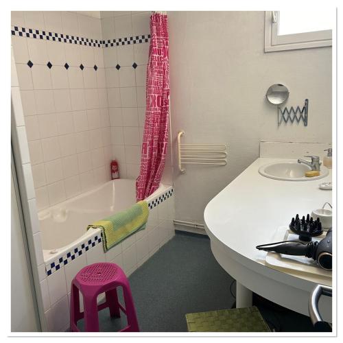 une salle de bain avec une baignoire, un lavabo et un tabouret rose dans l'établissement Charmant Rez-de-Jardin Tout Confort avec Parking, Calme Assuré, à Lempdes