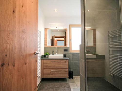 a bathroom with a sink and a mirror and a shower at Apartment Rosskopf by Interhome in Oberau
