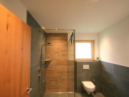 a bathroom with a shower and a toilet and a window at Apartment Rosskopf by Interhome in Oberau