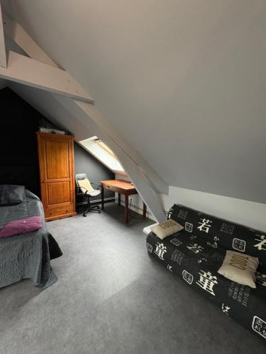 une chambre mansardée avec deux lits et une table dans l'établissement Doryan, à Sargé-lès-Le Mans