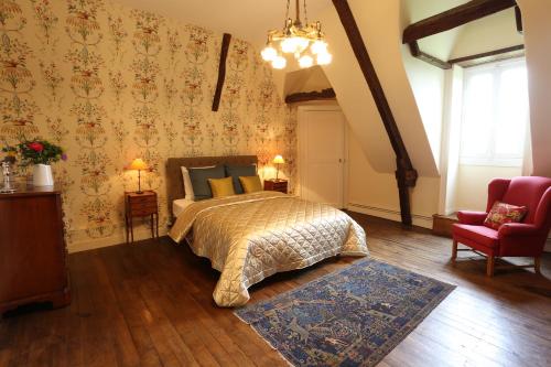 une chambre avec un lit et une chaise rouge dans l'établissement Coin de Paix, à Saint-Vincent-sur-Oust