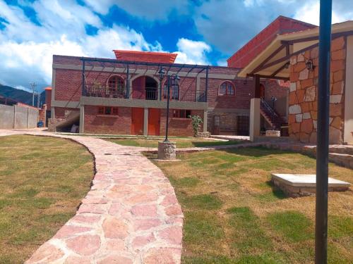 a brick building with a pathway leading to it at Hotel Norte Potosí in Torotoro