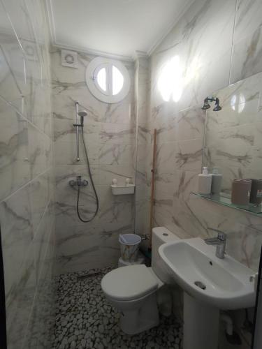 a bathroom with a toilet and a sink at Oasis Aglou in Aglou