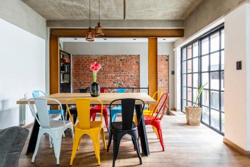 a dining room with a table and colorful chairs at Industrial House in Mendoza with Jacuzzi in Mendoza
