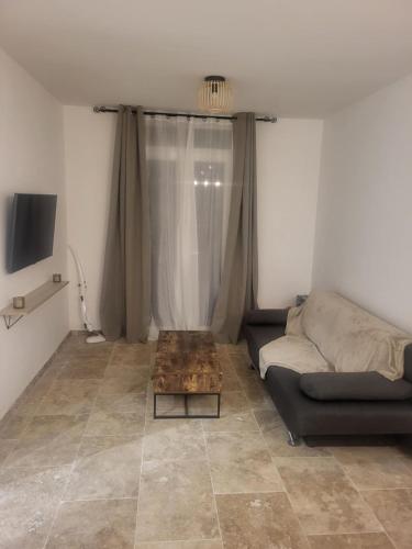 un salon avec un canapé et une table basse dans l'établissement T2 jardin neuf, à Béziers