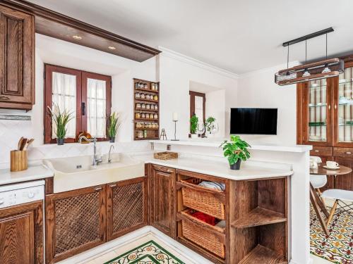 a kitchen with wooden cabinets and a sink at Holiday Home El patio de Lazaro by Interhome in Fuengirola