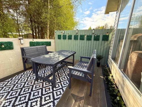 a patio with two benches and a table and chairs at Private Hot Tub & Spacious Decking Area in Northumberland, Dog-Friendly, Free Golf Access in Swarland