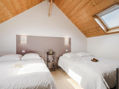deux lits dans une chambre avec plafonds en bois dans l'établissement Holiday Home La Colombe by Interhome, à Saint-Lunaire