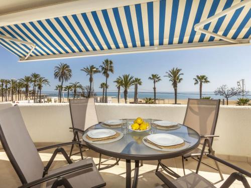 a dining table with chairs and a view of the beach at Apartment Marinada Cambrils by Interhome in Cambrils