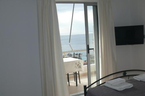 a bedroom with a bed and a view of the ocean at Hotel Erviliano in Borsh