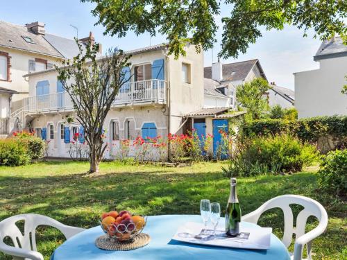 - une table avec une bouteille de vin et un bol de fruits dans l'établissement Apartment Charme du Pouliguen by Interhome, au Pouliguen