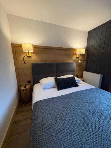 a bedroom with a large bed with two pillows on it at Les Reflets du Lac in Gérardmer