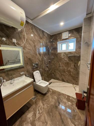 a bathroom with a toilet and a sink and a shower at Sangha Cottage in Abbottābād