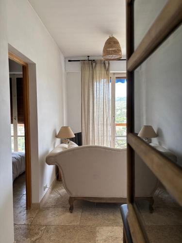 La salle de bains est pourvue d'une baignoire blanche et d'une fenêtre. dans l'établissement Cassis vue mer, à La Celle-sous-Gouzon