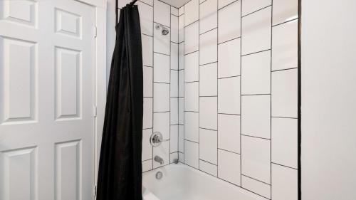a bathroom with a shower with a black shower curtain at Beautiful 4 bedroom home short walk to Niagara Falls in Niagara Falls