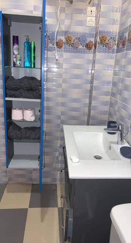 a bathroom with a white sink and a shower at Résidence Koto in Dakar
