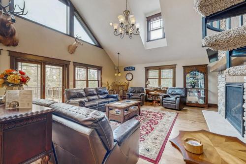 a living room with leather furniture and a fireplace at Grand Tomahawk Lodge in Tomahawk