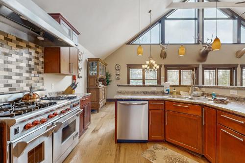 a large kitchen with a stove and a sink at Grand Tomahawk Lodge in Tomahawk