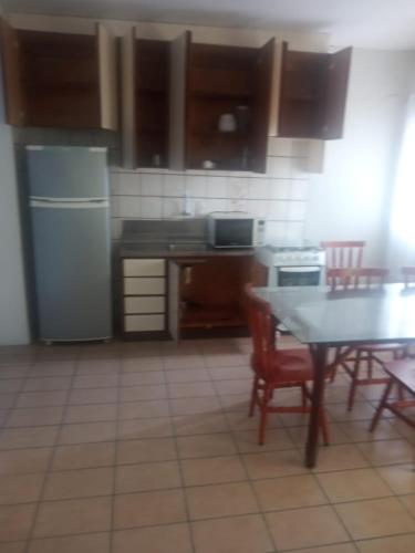 a kitchen with a table and a refrigerator at Pousada Del Mare in Florianópolis