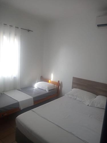 two beds in a room with a window at Pousada Del Mare in Florianópolis