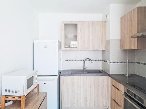 La cuisine est équipée d'un réfrigérateur blanc et d'un four micro-ondes. dans l'établissement Apartment Les Félibres by Interhome, à La Seyne-sur-Mer