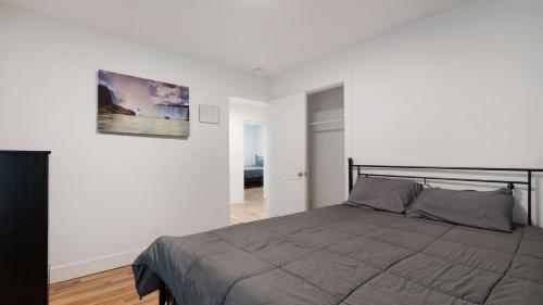 a bedroom with a bed and a picture on the wall at Walk to Niagara Falls! Newly Renovated 4 Bedrooms in Niagara Falls