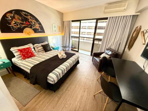 a bedroom with a bed and a desk and a window at Lindo Studio com Jacuzzi e sacada a 50m Av Paulista in Sao Paulo