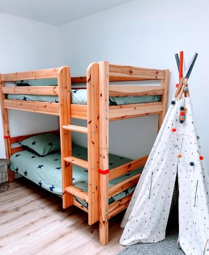 un lit superposé avec une échelle et un lit superposé avec une tente dans l'établissement Ty Ker iliz - petits commerces et plage accessibles à pied!, à Trélévern