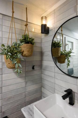 a bathroom with two plants in baskets and a mirror at Toutounis House Kazaviti in Mikros Prinos