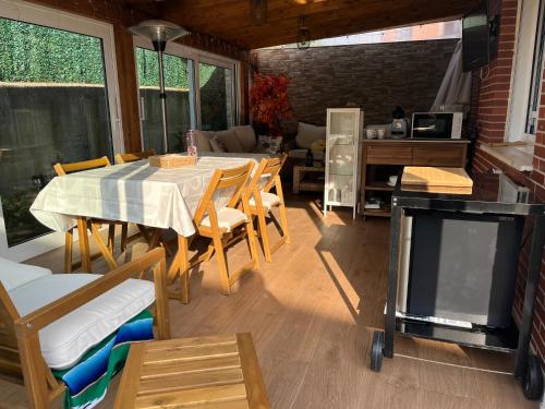 a dining room with a table and chairs and a tv at Habitaciones en chalet con jardín in Boó de Piélagos