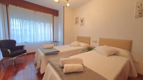 a hospital room with two beds and a chair at Vivenda Ponte Romana in Padrón