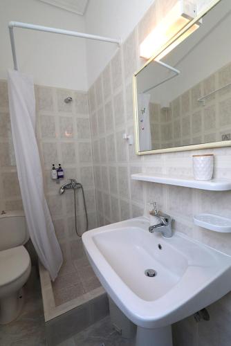 a bathroom with a sink and a toilet and a mirror at Casa alle terme in Loutra Edipsou