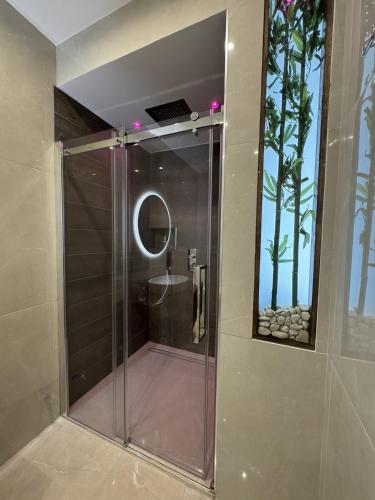 a shower in a bathroom with a mirror at Chilometro Mille Suites e Apartments in Otranto