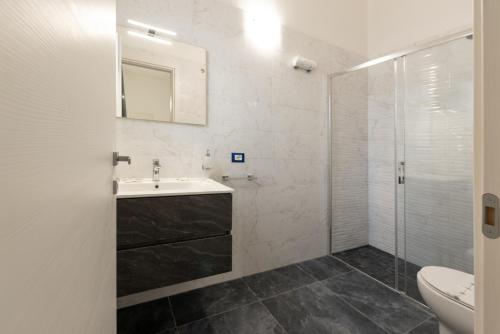 a white bathroom with a sink and a shower at ALG Apartments con Parcheggio in Porto Cesareo