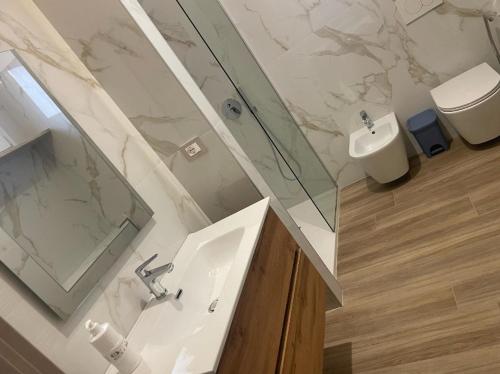 a bathroom with a sink and a shower and a toilet at Marconi B&B - Holiday Home in Marconia